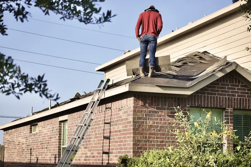Professional roofer working on a residential roof in Airport City